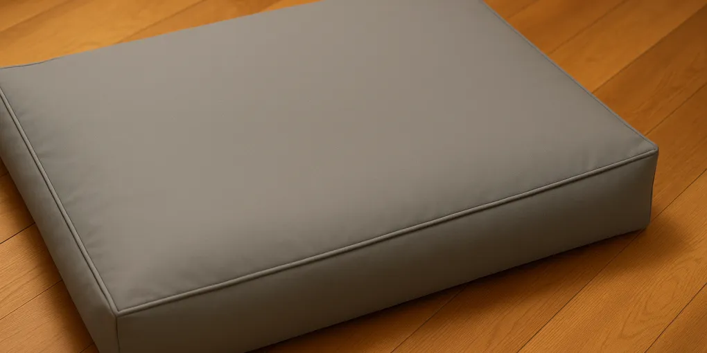 Waterproof dog bed cover in soft grey fabric on a dog mattress, clean and inviting with warm lighting